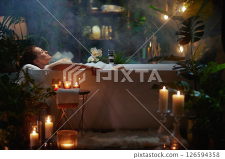 Serene Escape: Woman Relaxing in Bubble Bath 126594358
