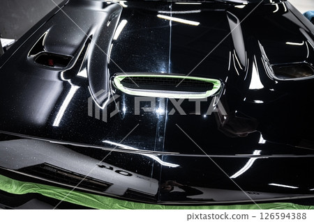 Car hood showing before and after paint correction 126594388