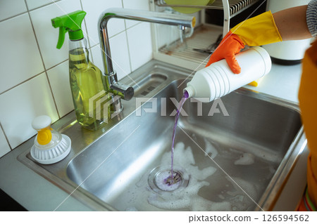 Pouring Drain Cleaner into Kitchen Sink 126594562