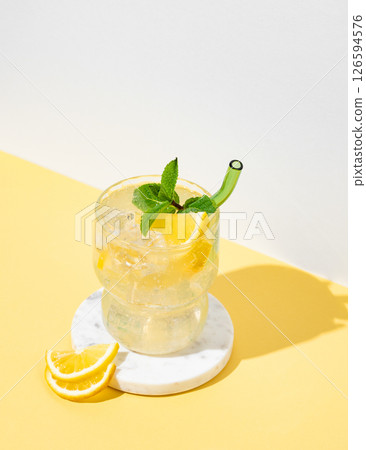 Fresh mocktail mojito with lemon, mint and ice. Citrus lemonade on a white yellow background. 126594576