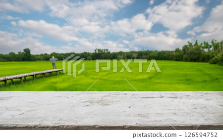 empty cement old table on blur rice field and cloud background, for your product placement or montage with focus to the table top in the foreground. blank shelf, shelves with copy space empty cement old table on blur rice field and cloud background, for your product placement or montage with focus to the table top in the foreground. blank shelf, shelves with copy space 126594752