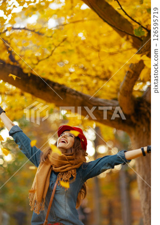 happy 40 years old woman in jeans shirt and red hat rejoicing 126595719