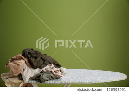 Earth-toned laundry pile on ironing board Earth-toned laundry pile on ironing board 126595961