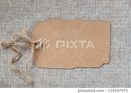 Empty craft paper tag, branding mockup, packaging, promotional design. Kraft paper tag with tied jute string on textured fabric background . Eco-friendly price tag, handmade label, natural packaging Empty craft paper tag, branding mockup, packaging, promotional design. Kraft paper tag with tied jute string on textured fabric background . Eco-friendly price tag, handmade label, natural packaging 126597472
