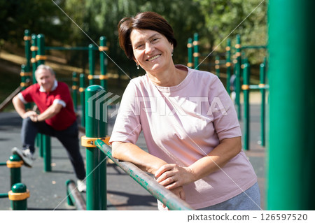 Elderly woman stands in a sports bar on an outdoor sports field 126597520