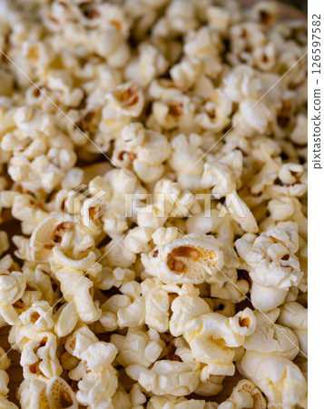 Butter salted popcorn on wooden table. 126597582