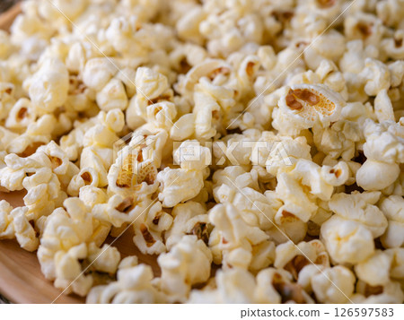 Butter salted popcorn on wooden table. 126597583