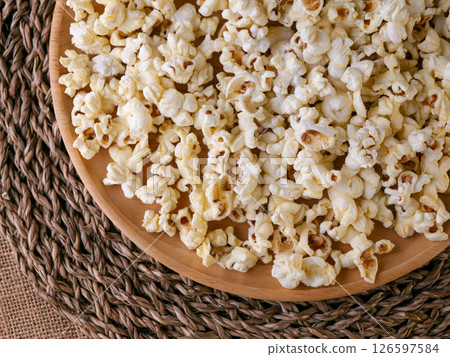 Butter salted popcorn on wooden table. 126597584