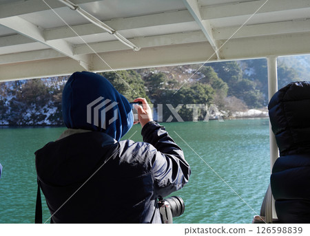 Tourists taking photos of the scenery on a sightseeing boat on a winter morning in the Shogawa Gorge 126598839