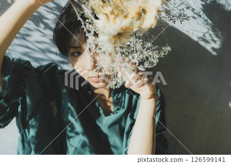A young woman in a green dress leaning against a wall A young woman in a green dress leaning against a wall 126599141