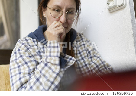 Pensive woman working from home is feeling stressed and anxious Pensive woman working from home is feeling stressed and anxious 126599739
