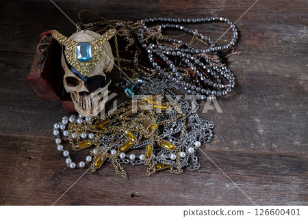 The pirate skull with treasure on wooden background. The pirate skull with treasure on wooden background. 126600401