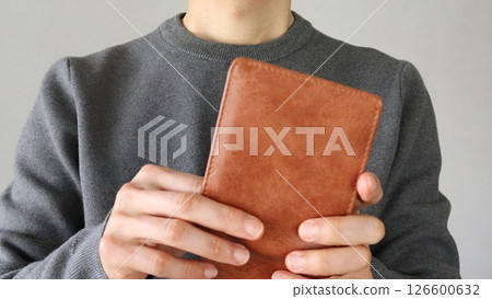 Close-up of a person holding a wallet 126600632