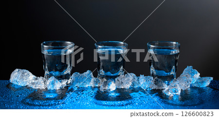 Vodka and crushed ice on a black table. Vodka and crushed ice on a black table. 126600823