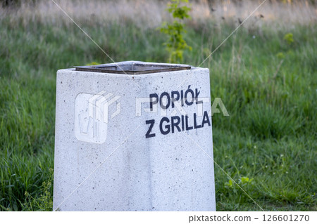 Outdoor public concrete ash bin with text Ash from grill and icon offers designated safe disposal point for hot ash in urban environment Outdoor public concrete ash bin with text Ash from grill and icon offers designated safe disposal point for hot ash in urban environment 126601270