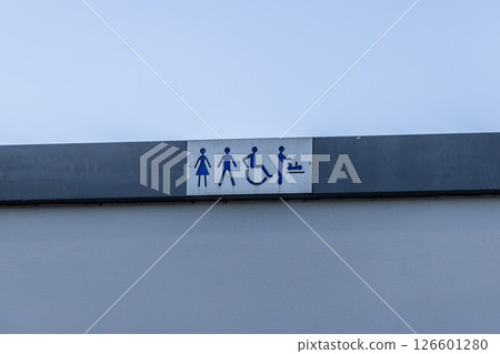 Public restroom sign with female male disabled and baby change icons on building facade indicating available facilities 126601280