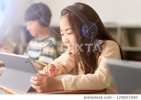小學生一邊看平板電腦一邊學習 126601980