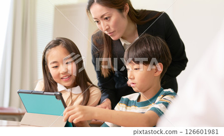 Elementary school students using tablets and teachers instructing them 126601981