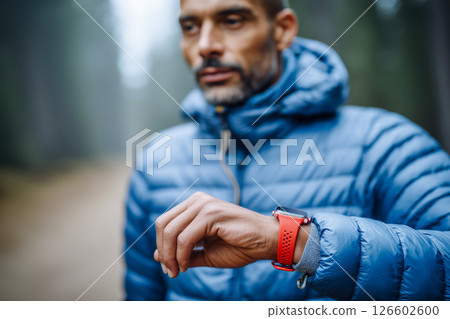A man wearing a blue jacket and a red watch A man wearing a blue jacket and a red watch 126602600