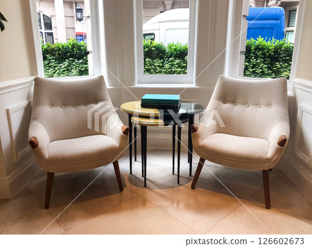 A book placed on a coffee table in the hotel lobby, creating a calm and inviting atmosphere. The soft light and elegant setting emphasize the peaceful and relaxed vibe of the space. A book placed on a coffee table in the hotel lobby, creating a calm and inviting atmosphere. The soft light and elegant setting emphasize the peaceful and relaxed vibe of the space. 126602673