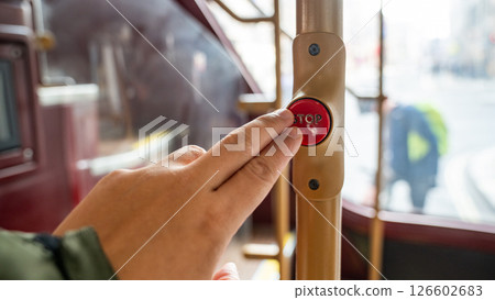 a Passenger Finger Pressing the Stop Button on a Red London Bus, Capturing a Moment in the Public Transport Experience. 126602683