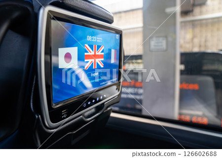 A language selection screen is displayed on a touch monitor mounted behind a bus seat. The interface shows flags and options for passengers to choose their preferred language while traveling. A language selection screen is displayed on a touch monitor mounted behind a bus seat. The interface shows flags and options for passengers to choose their preferred language while traveling. 126602688