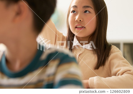 Female elementary school student raising her hand during class 126602809