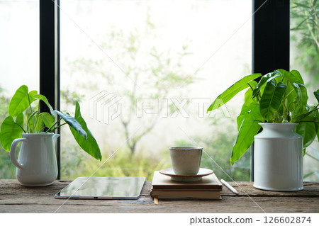 Earthenware teapot and tablet with plant pot by the window 126602874
