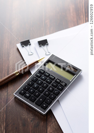 Documents and calculator clipped together 126602959