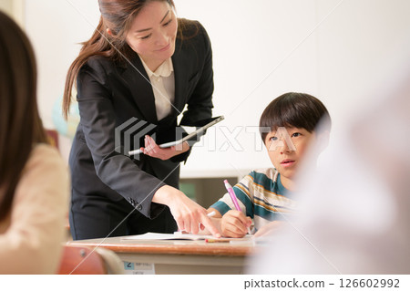 A female elementary school student studying and her teacher 126602992