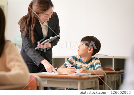 正在學習的小學生和微笑的老師 126602993