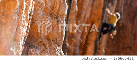 A man is climbing on the rocks in the mountains. A man is climbing on the rocks in the mountains. 126603431