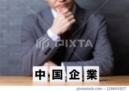 Chinese company block and middle-aged male businessman wearing a suit Chinese company block and middle-aged male businessman wearing a suit 126603927