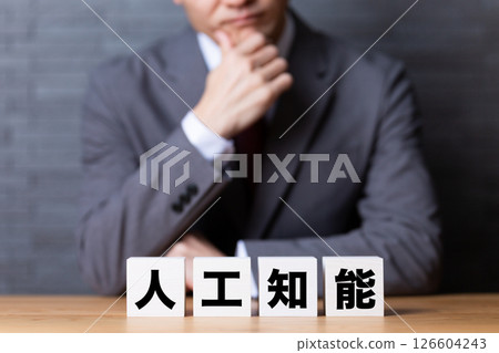 Artificial intelligence block and middle-aged male businessman wearing a suit and worried 126604243