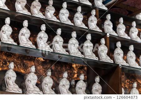 Rows of intricately crafted ceramic figurines are in Buddhist temple 126604873