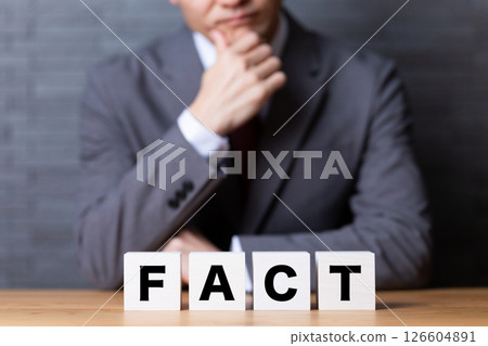 FACT block and a middle-aged male businessman wearing a suit and worried 126604891