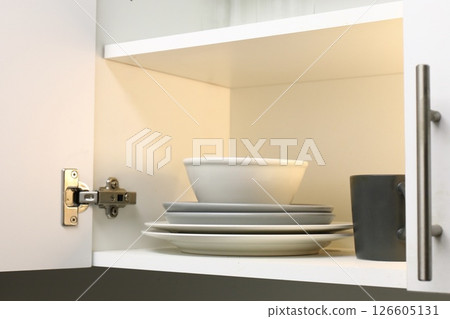kitchen cabinet with plates and dishes on the shelf kitchen cabinet with plates and dishes on the shelf 126605131
