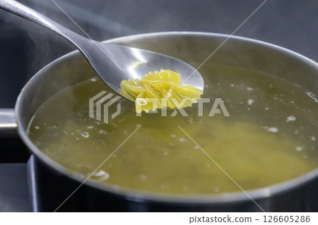 boiled farfalle pasta lifted from steaming pot with silver spoon over hot water boiled farfalle pasta lifted from steaming pot with silver spoon over hot water 126605286