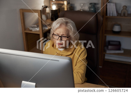 Focused elderly woman using desktop computer at home portrait shot 126605724