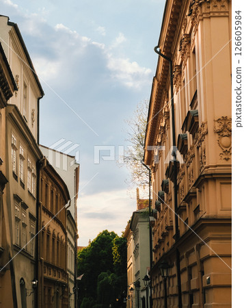 Colorful historic street revealing traditional architecture, sunlight illuminating pastel facades against vibrant blue sky and drifting clouds. Old town street with colorful buildings, architecture Colorful historic street revealing traditional architecture, sunlight illuminating pastel facades against vibrant blue sky and drifting clouds. Old town street with colorful buildings, architecture 126605984