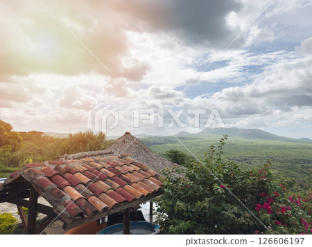 Stunning view of rolling hills and dramatic clouds from rustic rooftop at sunset 126606197