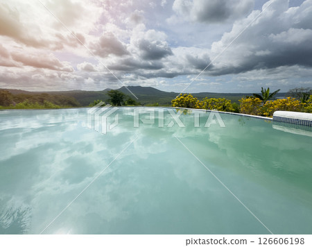 Stunning pool reflects clouds and mountains at sunset in serene landscape 126606198