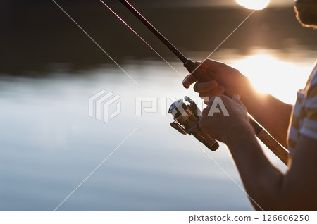 Peaceful evening fishing scene with detailed shots of hands holding rod. Peaceful evening fishing scene with detailed shots of hands holding rod. 126606250