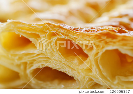 Freshly baked croissant reveals its beautifully layered, flaky texture, perfect for enjoying with coffee in a cozy breakfast nook as the sun rises 126606537