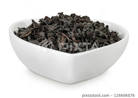 Dry black tea leaves in ceramic bowl isolated on white background Dry black tea leaves in ceramic bowl isolated on white background 126606876