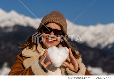 Snow Heart Woman Mountains Winter: Happy woman holding snow heart, sunny winter mountains backdrop. Snow Heart Woman Mountains Winter: Happy woman holding snow heart, sunny winter mountains backdrop. 126607562