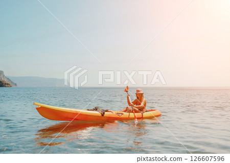 Kayak sea woman. Happy attractive woman with long hair in red swimsuit, swimming on kayak. Summer holiday vacation and travel concept. 126607596
