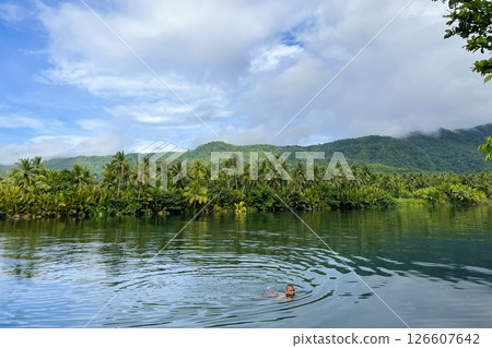 man swims in tropical river in wild jungle 126607642
