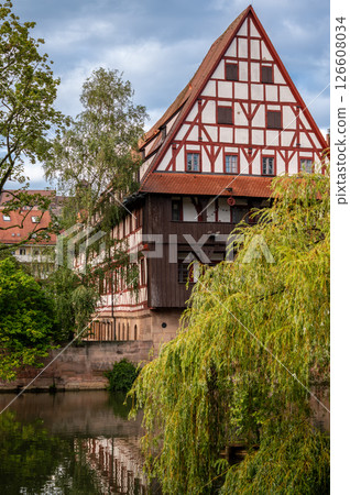 Nuremberg, Germany, August 2, 2023. Beautiful shot with an iconic image of the fairytale atmosphere of the place. On the beautiful summer day the half-timbered house is reflected in the water. 126608034