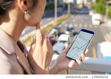 一位女士正在查看地圖應用程式以尋找目的地 一位女士正在查看地圖應用程式以尋找目的地 126608282